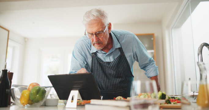 Reading, elderly or man with tablet for cooking recipe tutorial, lunch and guide in home. Kitchen, retirement or senior person learning on blog for ingredients instruction, food diet or meal steps