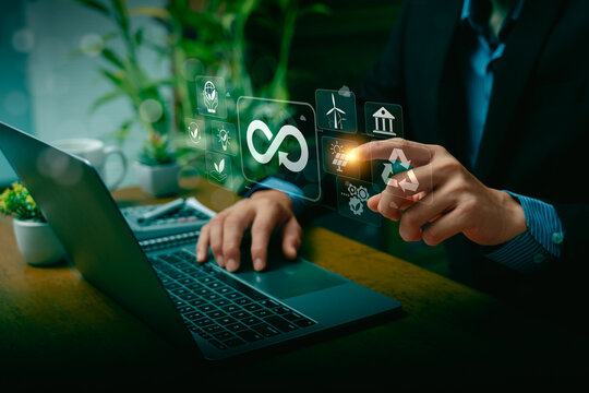 Businessman Using Laptop and Touching Virtual Screen with Infinity Symbol for Circular Economy, Highlighting Sustainable Development, Renewable Energy, Recycling, and Green Technology