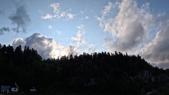 Clouds, like a soft white veil, envelop the peaks of majestic mountains. The best panoramic view of the mountains with passing clouds. Sky in 4K UHDTV format with accelerated shooting