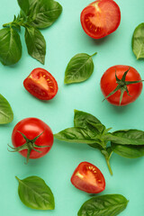 Cherry tomatoes and green basil on mint background. Vertical photo