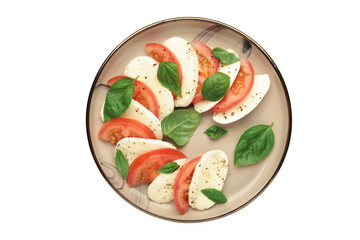 Italian Caprese salad with cherry tomatoes, mozzarella, basil on plate isolated on white background.