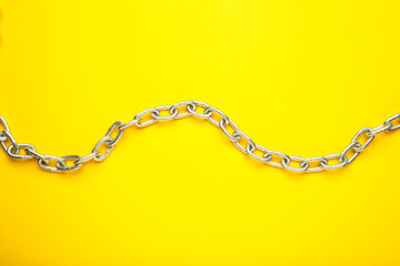 Iron chain of light metal on yellow background.