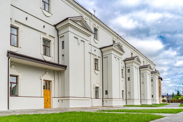 Detail of modern residential flat apartment building exterior. Fragment of new luxury house and home complex. Yellow sunlight. Black and white.