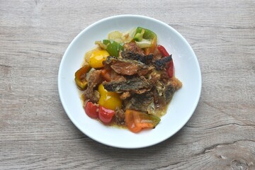 deep fried slice mango fish with bell pepper and onion in black pepper sauce on plate 