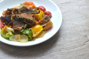 deep fried slice mango fish with bell pepper and onion in black pepper sauce on plate 