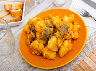 Braised beef with baked potato served with mayonnaise sauce in a restaurant