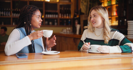 Relax, friends and women in conversation in coffee shop for hangout, reunion and bonding. Restaurant, cafe and people with beverage, talking and gossip for relationship, social chat and discussion