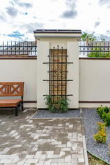 Back and front yard cottage garden, flowering plant and green grass lawn, brown pavement and orange...