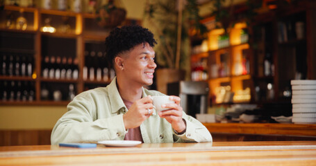 Man, coffee and thinking with smile at cafe for memory, drink and relax with inspiration at restaurant. Person, happy and tea cup with reflection, remember and perspective with beverage at diner