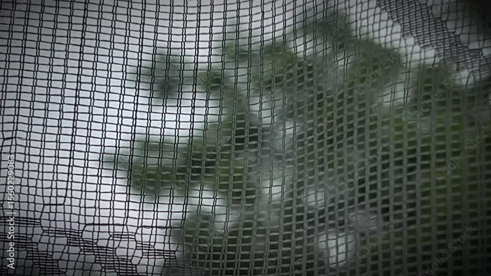 Wall mural close-up of a dark mesh screen with square grid texture and visible damage. a raw and textural backg