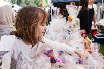 Little girl choosing lollies at the sweet stall at a school fair