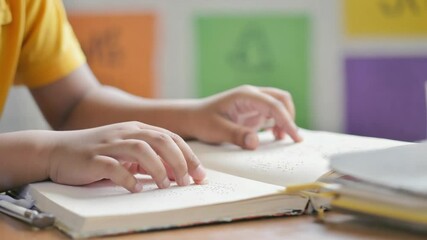 Child reading a Braille book in class. - Powered by Adobe