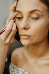 Applying makeup to model face