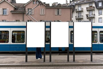 Tram stop in Zurich with three portrait format billboards.