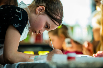 Young Girl Focused on Painting at Art Class