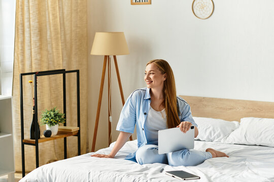 Young woman enjoys peaceful moments at home while working on her tablet in a cozy bedroom setting