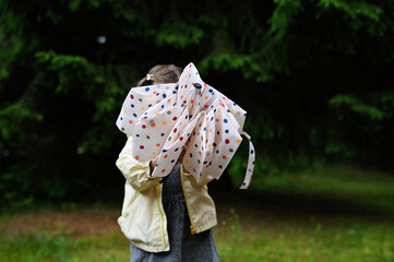 Kid girl with umbrella in yellow boots
