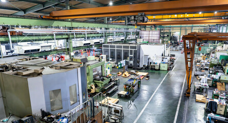 Fototapeta premium Aerial view of the inside of a factory with rows of machine tools
