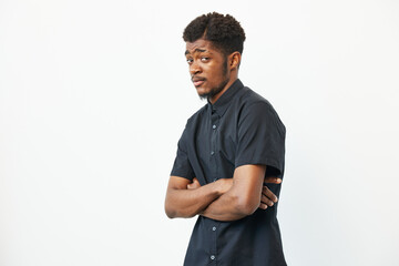 Black man with crossed arms, showcasing a confident demeanor. His stylish black shirt complements...