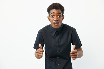 Black man showing enthusiasm with thumbs up, wearing a black shirt, expressing joy in a simple,...
