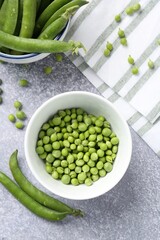 Fresh ripe green peas on grey table, flat lay
