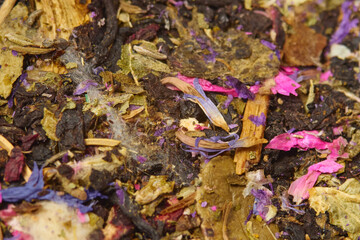 Dried herbal blend with colorful flowers and herbs displayed on a wooden surface