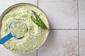 Protein powder and green peas on light tiled table, top view. Space for text