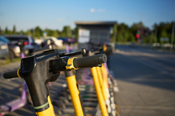 Colorful electric scooters parked in a bustling city area during the golden hour of the evening