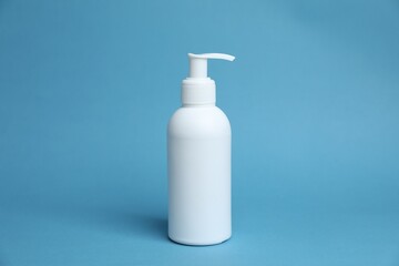 One white bottle of cosmetic product on light blue background