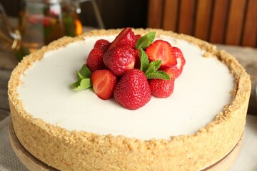 Tasty cheesecake with strawberries and mint on table, closeup