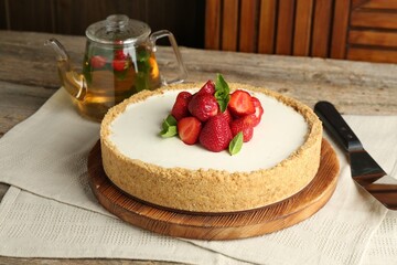 Tasty cheesecake with strawberries and mint on wooden table, closeup