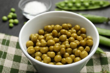 Pickled peas, salt and pods on black table, closeup