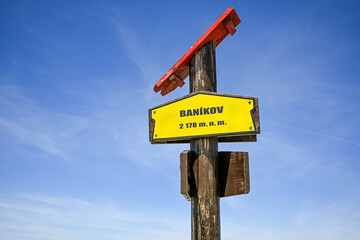 Yellow tourist sign marking Baníkov peak (2178 m) in the High Tatras National Park in Slovakia