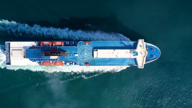 Aerial overhead tracking view of a passenger RoRo (Roll on Roll off) ship crossing the mediterranean sea with speed