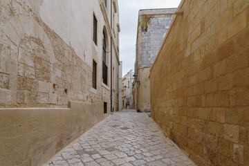 A narrow alleyway lined with colored mansions in Otranto, Apulia, Southern Italy