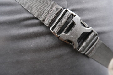 Close-up of black plastic buckle on fabric strap