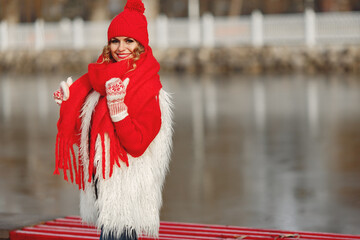 Woman in knitted winter hat and scarf looking at camera with smile
