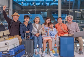 Three generation family with friends waiting for flying in the airport for airline...
