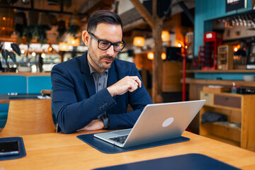 Business Professional Working on a Laptop in a Chic Cafe Environment