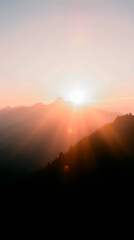 Serene Pastel Sunrise Over Misty Mountain Range.