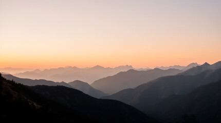 Serene Pastel Sunrise Over Misty Mountain Range.