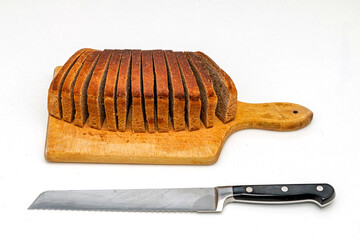 Dark brown rye healthy wholemeal bread with knife on wooden cutting board