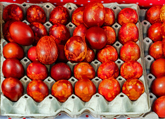 Red coloured cooked Easter chicken eggs sold outside on market during festive period