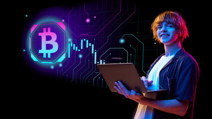 Young adult examines cryptocurrency data on a laptop depicting a Bitcoin symbol in a high tech...