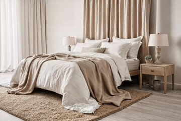 Modern bedroom interior with soft sand-colored draping and natural fiber rug under white floor