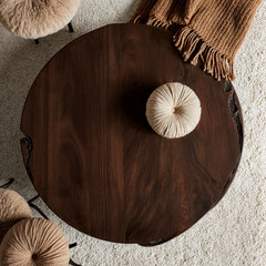 Dark walnut coffee table with organic edges, bouclé pouf and textured earthen blanket