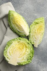 Pieces of fresh cabbage on grey table, flat lay