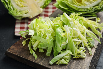 Cut fresh green cabbage on black table, closeup
