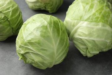 Fresh green cabbages on grey table, closeup