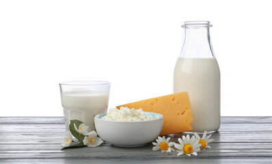 Different fresh dairy products and flowers on grey wooden table against white background